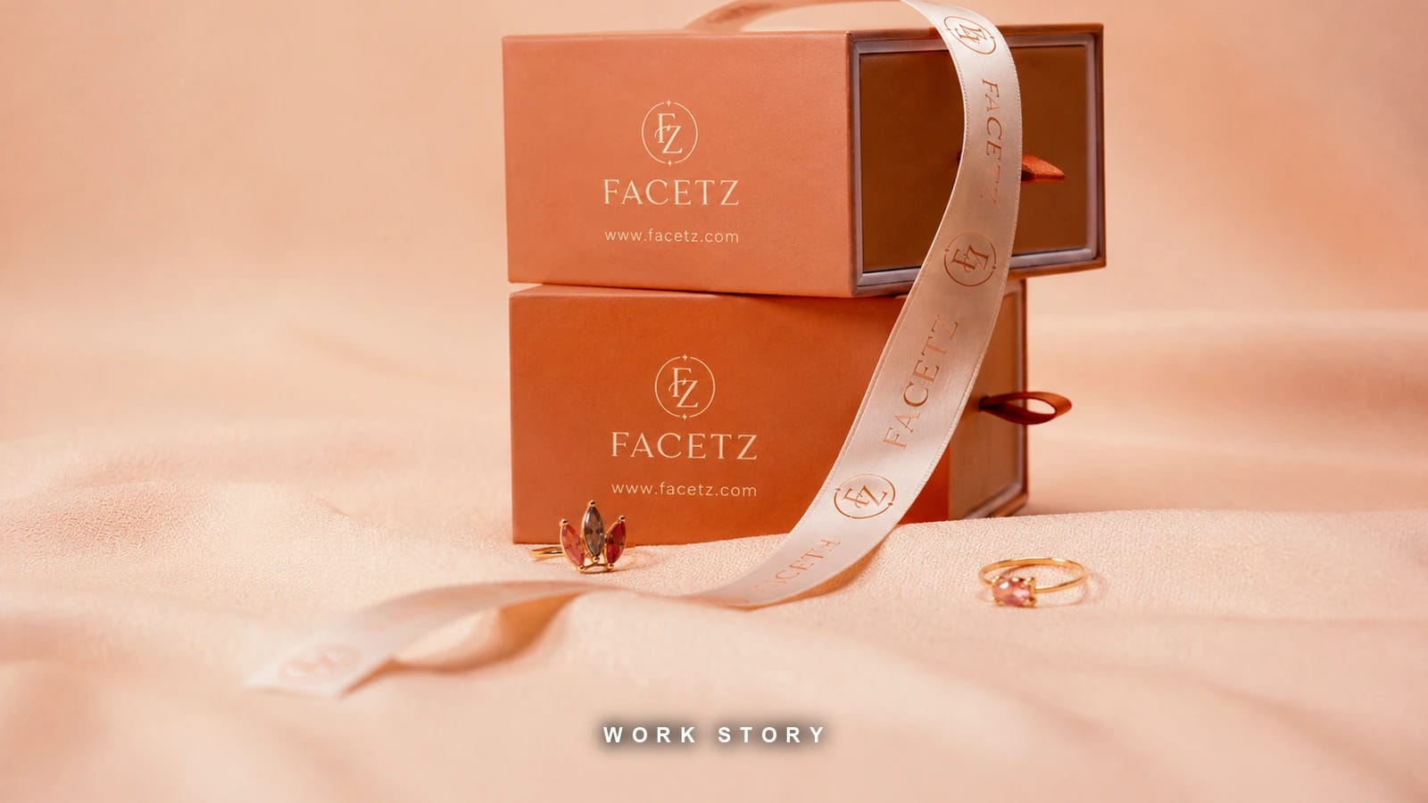 FACETZ packaging — stacked terracotta jewellery boxes with a foil monogram and printed ribbon