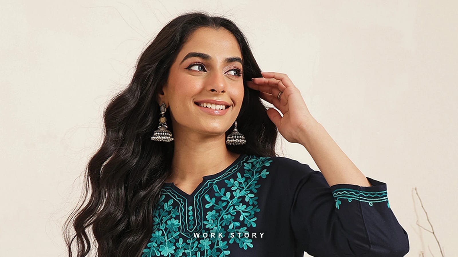 A FEMBLISS navy kurti with teal floral embroidery, shot on the brand's model against a neutral ground